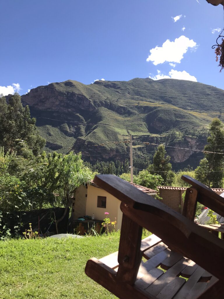 A wooden rocking chair overlooking a quiet peruvian andes mountain landscape, symbolizing rest and reflection after birth.
